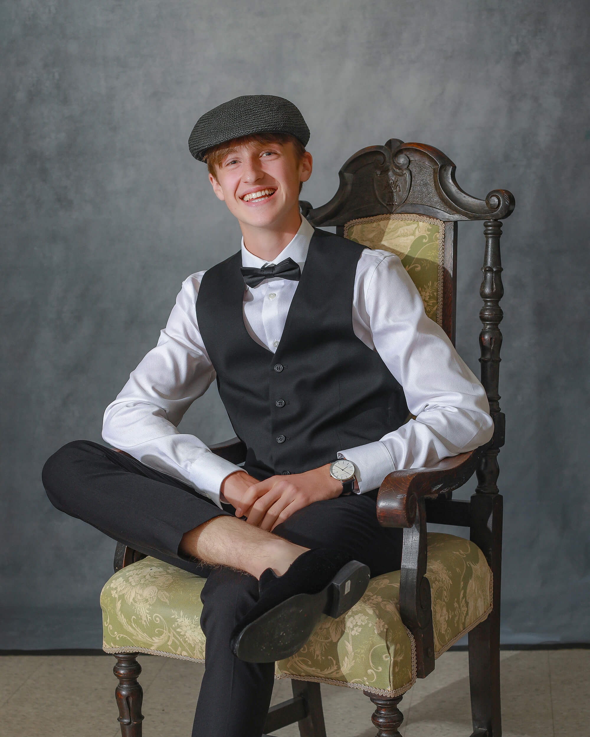 Grad styles in vintage clothes sitting on an antique chair